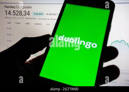 SAO PAULO, BRÉSIL - 01 juin 2021 : smartphone avec logo de l'application en langue Duolingo à l'écran et arrière-plan flou avec tableau d'index de stock Nasdaq. Duolingo Banque D'Images