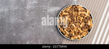 Pâtes en sauce crémeuse avec foie de poulet sur une assiette ronde sur fond sombre. Vue de dessus, plan d'appartement Banque D'Images