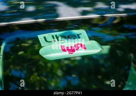 Les logos Lyft et Uber sur les autocollants fixés à la vitre arrière font la promotion d'un véhicule offrant des trajets partagés dans la Silicon Valley - San Francisco, Californie, États-Unis Banque D'Images