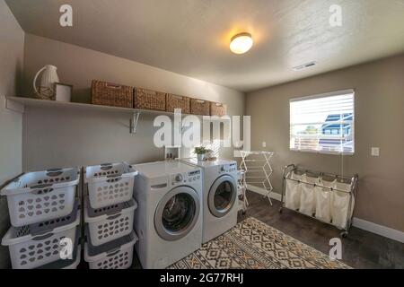 Buanderie spacieuse avec fenêtre et beaucoup de paniers de rangement Banque D'Images
