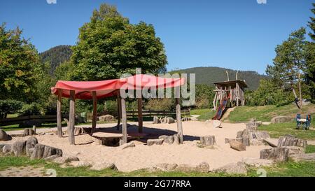 Terrain de jeu dans le parc avec toiture en textile sur des piquets en bois Banque D'Images