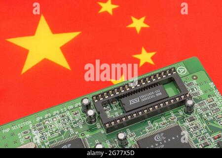 Drapeau national chinois avec carte de circuit imprimé verte avec prise EPROM vide. Pour 2021, pénuries de puces informatiques intégrées, pénuries de semi-conducteurs. Banque D'Images