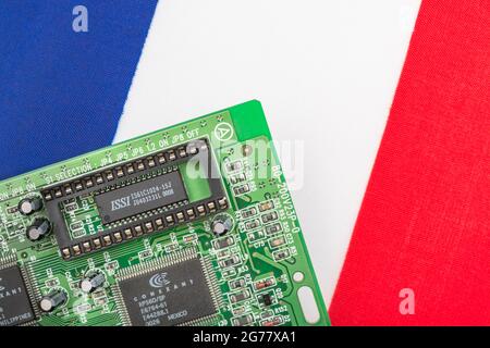 Drapeau tricolore français avec carte de circuit imprimé verte avec prise EPROM vide. Pour 2021, pénuries de puces informatiques intégrées, pénuries de semi-conducteurs. Banque D'Images