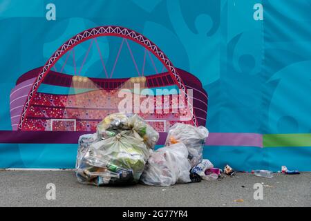 Wembley Park, Royaume-Uni. 12 juillet 2021. Des milliers de fans d'Angleterre ont quitté le parc Wembley couvert de détritus et sentant comme une brasserie après le comportement ahurant d'hier, avant, pendant et après la finale Euro 2020 entre l'Italie et l'Angleterre au stade Wembley. L'équipe de nettoyage a travaillé tout au long de la nuit pour ranger les déchets, y compris les drapeaux jetés, les panneaux, les bouteilles de bière et les canettes, les sacs en verre et en plastique cassés. Amanda Rose/Alamy Live News Banque D'Images