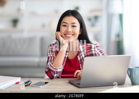 Portrait de la jeune femme asiatique freelancer assis au bureau avec ordinateur portable Banque D'Images