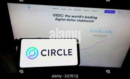 Personne détenant un smartphone avec le logo de la société de paiement américaine Circle Internet Financial Limited à l'écran devant le site Web. Mise au point sur l'affichage du téléphone. Banque D'Images