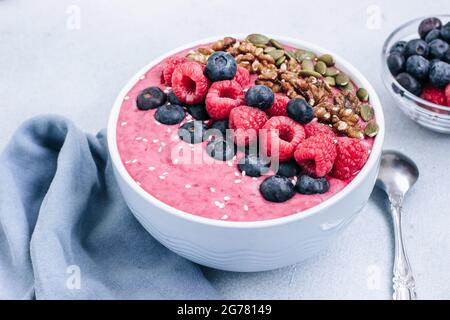 Bol de smoothies Acai aux framboises, aux bleuets, aux noix, aux graines de citrouille et au sésame Banque D'Images