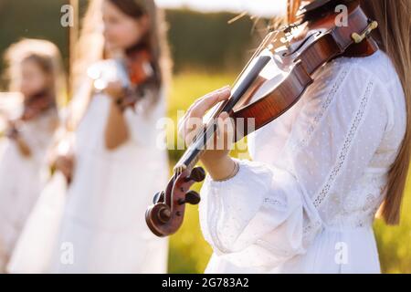 Accent sélectif sur le violon d'une jeune fille jouant à l'extérieur pendant le festival d'été Banque D'Images