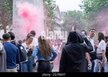 Les fans de football anglais qui chantent et laissent échapper les fusées se rassemblent dans le centre de Londres près de la place Trafalgar à l'euro 2020 final, en Angleterre Banque D'Images