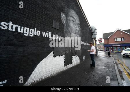 Ed Wellard, de Withington, fait passer des bandes-poubelles sur des textes offensifs sur la fresque de l'attaquant de Manchester United et du joueur d'Angleterre Marcus Rashford sur le mur du Coffee House Cafe sur Copson Street, Withington, qui semblait vandalisé le matin après que l'équipe de football d'Angleterre ait perdu la finale de l'UEFA Euro 2021. Date de la photo: Lundi 12 juillet 2021. Banque D'Images