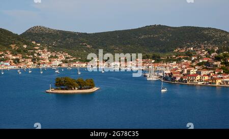 Iles Ioniennes, Ithaka, Baie de Molos, Vathi, vue sur la Baie de Kathis et l'îlot Lazareto, bateaux à voile, eau bleue, ciel bleu clair avec des nuages clairs collines vertes Banque D'Images