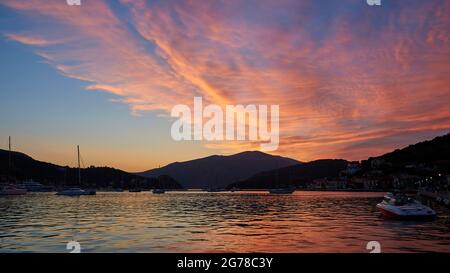 Iles Ioniennes, Ithaka, Baie de Molos, Vathi, crépuscule, Vue de Vathi à la baie, voiliers, nuages de voile illuminés de rose sur la baie, ciel bleu, mer sombre Banque D'Images