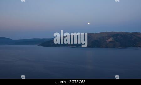 Iles Ioniennes, Ithaka, île d'Odysseus, pleine lune, matin d'humeur, Vue sur Kefalonia, pleine lune se dresse au-dessus de Kefalonia Banque D'Images