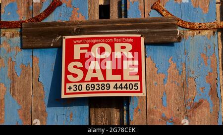 Îles Ioniennes, Ithaca, île d'Odysseus, nord-ouest, village de montagne Exogi, Volets bleus altérés, panneau imprimé indiquant « À VENDRE » Banque D'Images