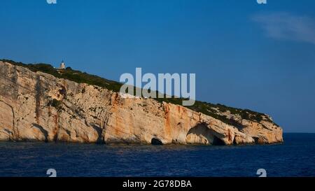 Îles Ioniennes, Zakynthos, côte nord-est, Grottes bleues, lumière du matin, mer dans le tiers inférieur, bleu foncé, grottes au-dessus, phare sur la côte rocheuse, ciel bleu Banque D'Images