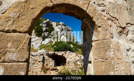 Îles Ioniennes, Zakynthos, montagne près de la ville de Zakynthos, Monte Yves, monastère sur le sommet, Panagia Skopiotissa, XVe siècle après J.-C., se dresse sur les ruines d'un ancien temple Artemis, ciel bleu foncé, vue à travers l'arche d'un mur de pierre à d'autres bâtiments et au sommet d'une colline rocheuse Banque D'Images