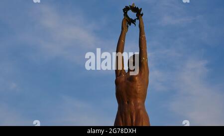 Zakynthos, ville de Zakynthos, place Solomos, lumière du matin, statue de liberté en bronze, section de la partie supérieure de la statue, nuages blancs dans le ciel bleu Banque D'Images