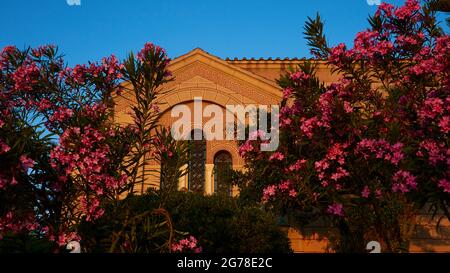 Ville de Zakynthos, ville de Zakynthos, église de Saint Dionysius, lumière du matin, toit en pignon de l'église, buissons d'oléander en premier plan Banque D'Images