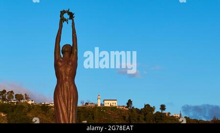 Zakynthos, ville de Zakynthos, place Solomos, Statue de la liberté en bronze, ciel bleu, lumière du matin, nuages uniques, église sur la colline en arrière-plan Banque D'Images