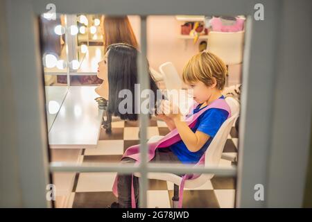 Garçon coiffeur, jour de choix de profession, jouer chez le coiffeur dans le salon de beauté pour enfants, coiffeur, coiffure, coiffure emploi Banque D'Images