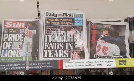 Londres, Royaume-Uni, 12 juillet 2021 : les journaux en première page couvrent la défaite de l'Angleterre dans la finale de l'Euro 2020. L'équipe de football des hommes d'Angleterre a perdu des peines contre l'Italie à Wembley hier soir. La couverture met en avant la déception mais aussi la fierté des jeunes de l'équipe diverse, qui ont malheureusement été victimes d'abus raciaux en ligne depuis le jeu. Beaucoup de documents ont utilisé des photos du directeur de l'Angleterre Gareth Southgate consolant Bukayo Saka après sa tentative de pénalité a été sauvé par le gardien de but italien. Anna Watson/Alay Live News Banque D'Images