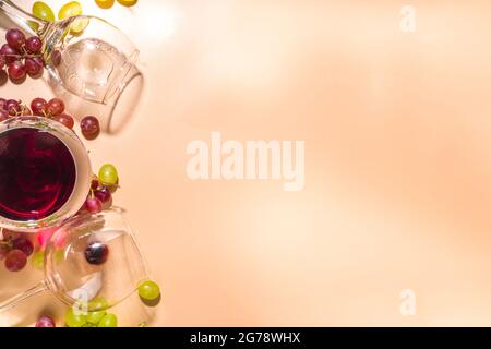 Verres de vin rouge et blanc avec soleil et ombres, avec bouteille et carafe, bouquet de raisins, sur fond crémeux, vue sur le dessus plat vin Banque D'Images