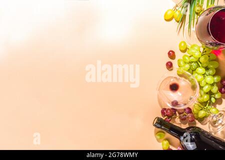 Verres de vin rouge et blanc avec soleil et ombres, avec bouteille et carafe, bouquet de raisins, sur fond crémeux, vue sur le dessus plat vin Banque D'Images