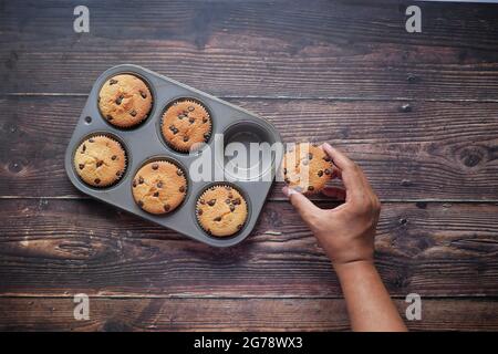 Vue de dessus de l'homme tenant main gâteau de tasse de chocolat sur la table Banque D'Images