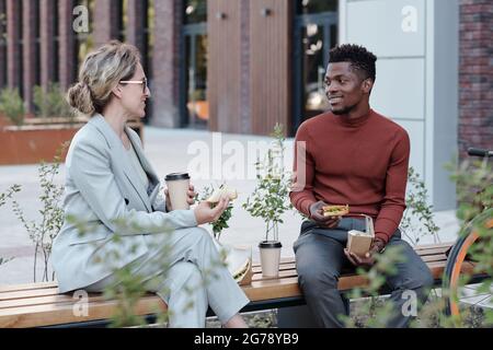 Deux jeunes collègues multiraciaux déjeunent à l'extérieur Banque D'Images