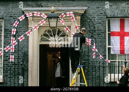 LONDRES 12 juillet 2021. Les membres du personnel retirent les banderoles de l'Angleterre attachées aux rails de Downing Street un jour, l'équipe nationale de football de l'Angleterre avait perdu la finale de l'UEFA Euro 2020 sur des sanctions contre l'Italie à Wembley le dimanche 11 juillet. Les joueurs d'Angleterre Marcus Rashford, Jadon Sancho et Bukayo Saka ont été ciblés sur les médias sociaux avec des abus raciaux après avoir manqué leurs sanctions lors de la fusillade qui a porté la victoire à l'équipe italienne. Credit amer ghazzal/Alamy Live News Banque D'Images