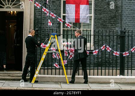 LONDRES 12 juillet 2021. Les membres du personnel retirent les banderoles de l'Angleterre attachées aux rails de Downing Street un jour, l'équipe nationale de football de l'Angleterre avait perdu la finale de l'UEFA Euro 2020 sur des sanctions contre l'Italie à Wembley le dimanche 11 juillet. Les joueurs d'Angleterre Marcus Rashford, Jadon Sancho et Bukayo Saka ont été ciblés sur les médias sociaux avec des abus raciaux après avoir manqué leurs sanctions lors de la fusillade qui a porté la victoire à l'équipe italienne. Credit amer ghazzal/Alamy Live News Banque D'Images