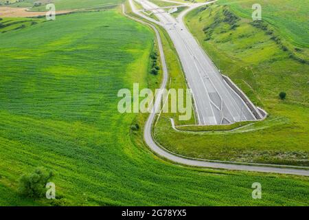 Vue de dessus sur l'entrée du tunnel de l'autoroute recouverte d'herbe verte Banque D'Images