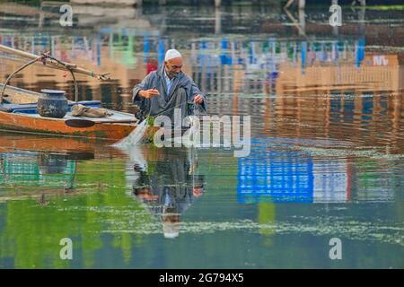 Srinagar, Inde 07 - juillet 2018 : style de vie dans le lac Dal, l'homme local utilise le bateau shikara, pêche avec un filet dans le lac Srinagar. Etat de Jammu-et-Cachemire, Banque D'Images