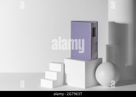 Journal violet sur des formes de papier 3d blanc avec espace de copie Banque D'Images
