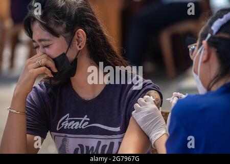 Jakarta, Indonésie. 12 juillet 2021. Une femme reçoit une dose du vaccin COVID-19 au cours d'une campagne de vaccination mobile dans les zones densément peuplées du sud de Jakarta, Indonésie, le 12 juillet 2021. Credit: Veri Sanovri/Xinhua/Alay Live News Banque D'Images