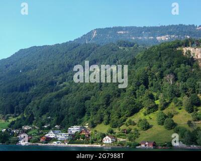 Excursion en bateau sur le lac de Lucerne. Vue sur les maisons sur la rive du lac depuis le bateau. En arrière-plan il y a une montagne Banque D'Images