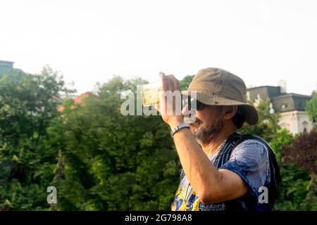 portrait d'un homme avec un chapeau prenant une photo avec un téléphone, Banque D'Images