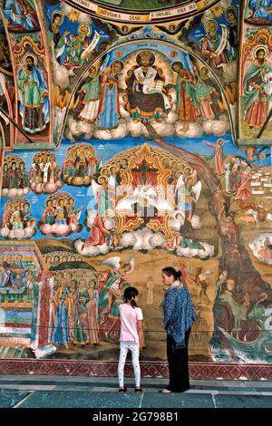 Femme et enfant devant une murale au monastère de Rila, en Bulgarie. Banque D'Images