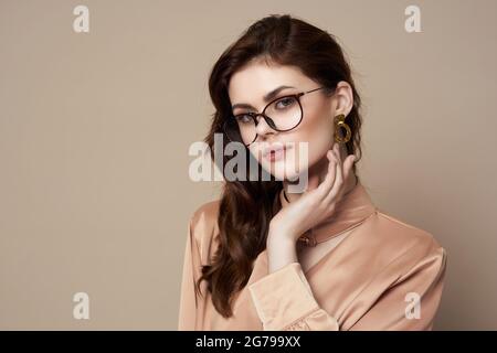 jolie femme en chemise beige avec verres glamour luxe isolé arrière-plan Banque D'Images