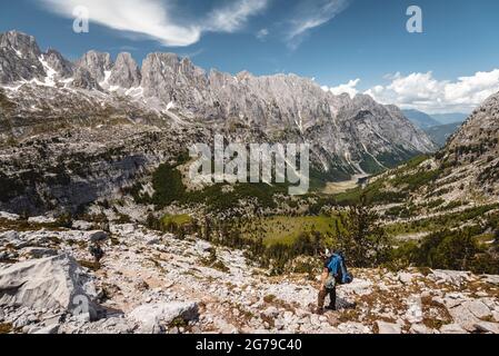 Sous un soleil éclatant, un seul randonneur donne sur le paysage du parc national de Prokletije jusqu'à une immense chaîne de montagnes, l'Albanie Banque D'Images