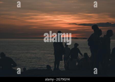 Un endroit magique: Les gens applaudissent quand le soleil se couche à Arpoador rocher avec vue sur la plage d'Ipanema et les montagnes de Morro Dois Irmaos et Leblon dans le dos. Appareil-photo: Leica M10 Banque D'Images