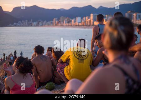 Un endroit magique: Les gens applaudissent quand le soleil se couche à Arpoador rocher avec vue sur la plage d'Ipanema et les montagnes de Morro Dois Irmaos et Leblon dans le dos. Appareil-photo: Leica M10 Banque D'Images