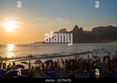 Un endroit magique: Les gens applaudissent quand le soleil se couche à Arpoador rocher avec vue sur la plage d'Ipanema et les montagnes de Morro Dois Irmaos et Leblon dans le dos. Appareil-photo: Leica M10 Banque D'Images