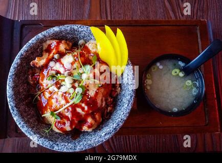 Vue de dessus sur le don de tori japonais, poulet grillé sur lit de riz, avec cornichon jaune, fromage Mozzarella, sauce teriyaki et soupe miso. Banque D'Images