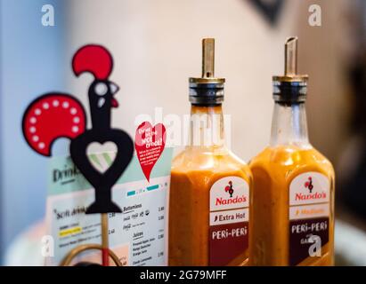 Bournemouth, Royaume-Uni.6 novembre 2019.Image du restaurant Nando's avec de la sauce extra chaude peri peri avec le logo Nando's flou à côté. Banque D'Images