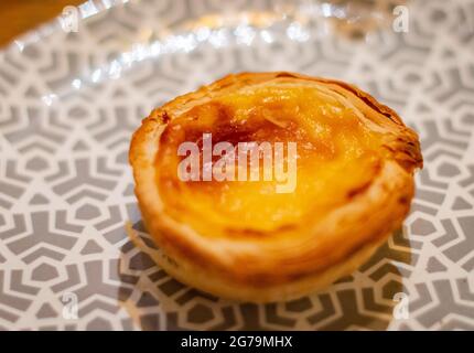 Une tarte aux œufs portugais placée sur une assiette Banque D'Images