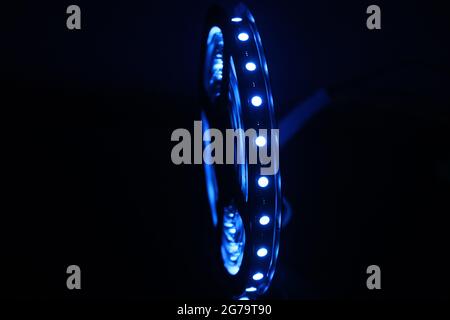 Bande de LED bleue brillante isolée sur fond sombre. Bande verticale de rouleau de LED Banque D'Images