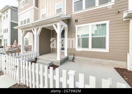 Extérieur d'une maison avec porte avant sombre avec couronne et clôture en bois et porte Banque D'Images