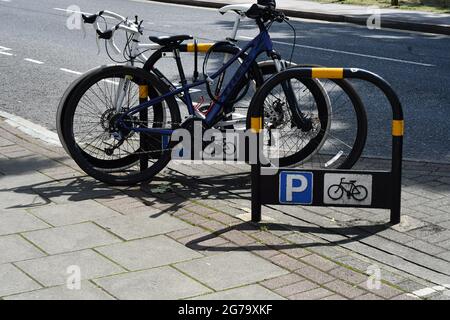 Parking pour vélos sur le côté d'une route par une journée ensoleillée à Londres Banque D'Images