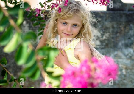 belle jeune fille blonde et fleurs roses Banque D'Images